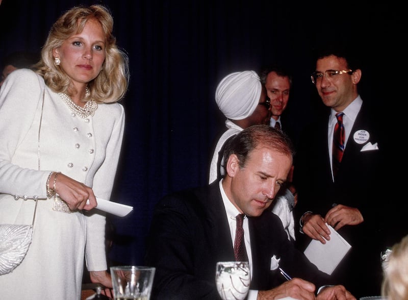 American educator Dr Jill Biden (left) stands behind her husband, American politician US Senator (and future Vice President) Joe Biden, as he signs autographs after his keynote address to an Illinois Democratic Party Unity Dinner, Chicago, Illinois, May 11, 1987. (Photo by Mark Reinstein/Corbis via Getty Images)