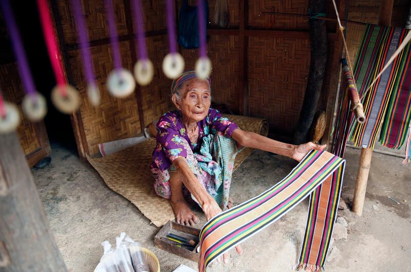 A lombok Sasak woman holds a woven fabric as she sells at Sade Village in Lombok, Indonesia. EPA