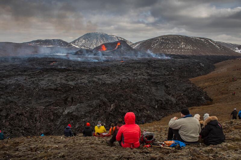 People watch the Lava flows from an eruption. AP Photo