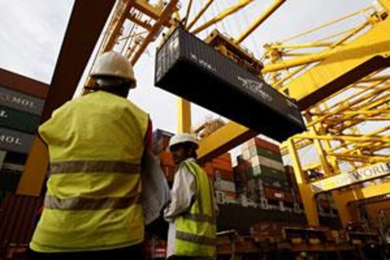 Two employees of DP World supervise uploading the containers at the Jebel Ali port terminal 1 in Dubai.