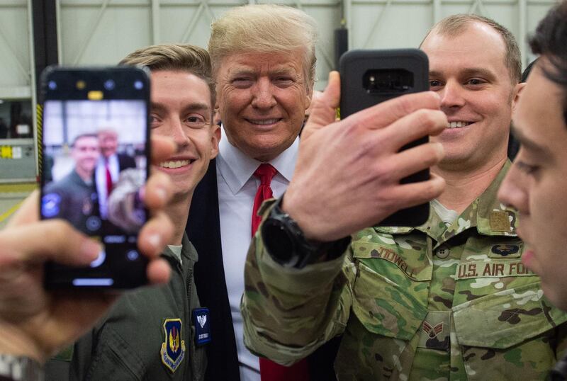 US President Donald Trump greets members of the US military during a stop at Ramstein Air Base in Germany, on December 27, 2018. President Donald Trump used a lightning visit to Iraq -- his first with US troops in a conflict zone since being elected -- to defend the withdrawal from Syria and to declare an end to America's role as the global "policeman." / AFP / SAUL LOEB
