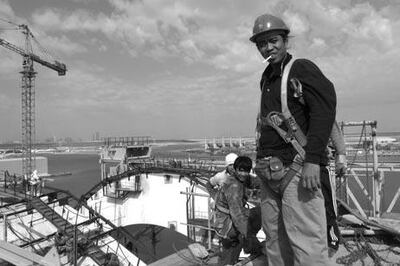Rene Padirayon on top of the main arch in autumn 2009. Work on the Sheikh Zayed Bridge helped thousands of employees build better lives for the families they had left behind to go to work. Courtesy Roy Lengweiler
