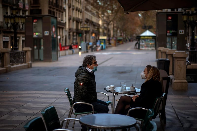 A couple sit on a terrace bar at the empty street of Las Ramblas in central Barcelona, Spain. AP