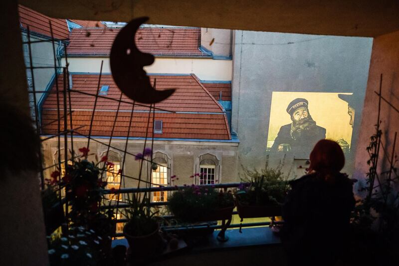 Resident Constanze Obst watches the movie Loving Vincent a projection on a facade from a balcony in Berlin, Germany.  EPA