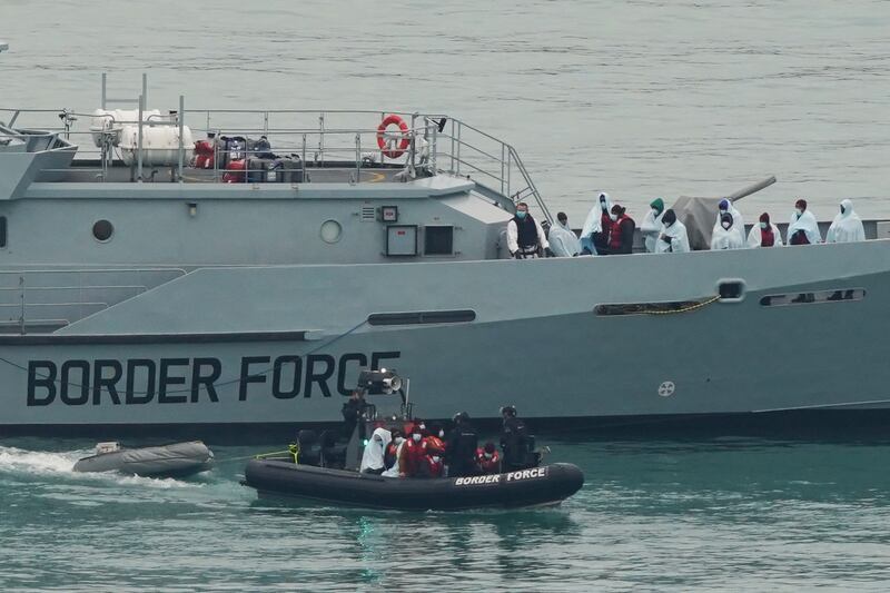A group of migrants is taken to Dover, England, by Border Force officers on December 16. PA