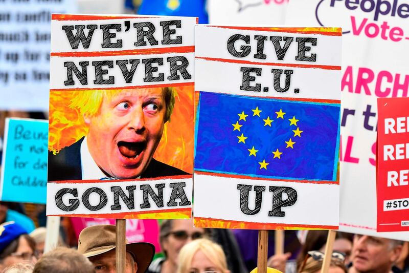 Demonstrators hold placards and EU and Union flags as they take part in a march. AFP