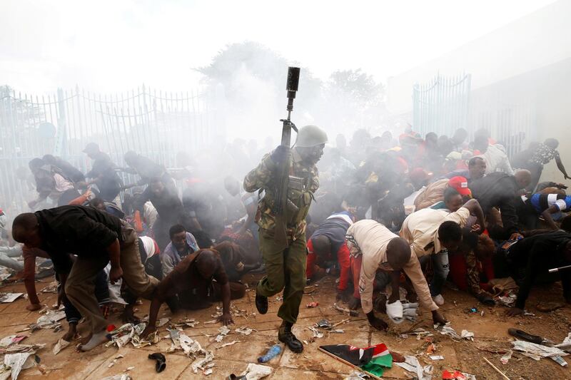 People fall as police fire tear gas to try control a crowd trying to force their way into a stadium to attend the inauguration of president Uhuru Kenyatta at Kasarani Stadium in Nairobi, Kenya on November 28, 2017. Baz Ratner / Reuters