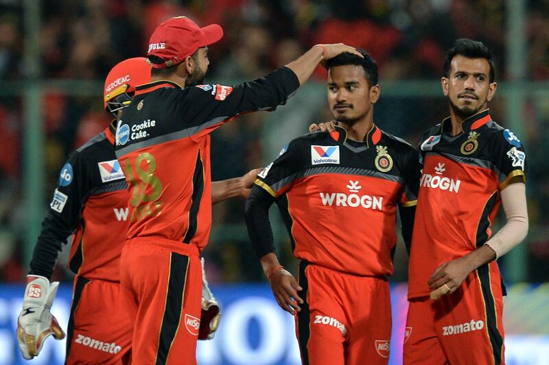 Royal Challengers Bangalore cricketer Pawan Negi (2ndR) is congratulated by team captain Virat Kohli (2ndL) after he bowled Kolkata Knight Riders batsman Chris Lynn out for 43 runs during the 2019 Indian Premier League (IPL) Twenty20 cricket match between Royal Challengers Bangalore and Kolkata Knight Riders at The M. Chinnaswamy Stadium in Bangalore on April 5, 2019. (Photo by Manjunath KIRAN / AFP) / IMAGE RESTRICTED TO EDITORIAL USE - STRICTLY NO COMMERCIAL USE