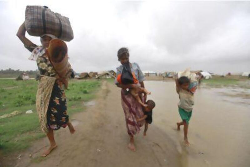 A woman and her children evacuate before Cyclone Mahasen was set to land at a Rohingya refugee camp outside of Sittwe, Myanmar.