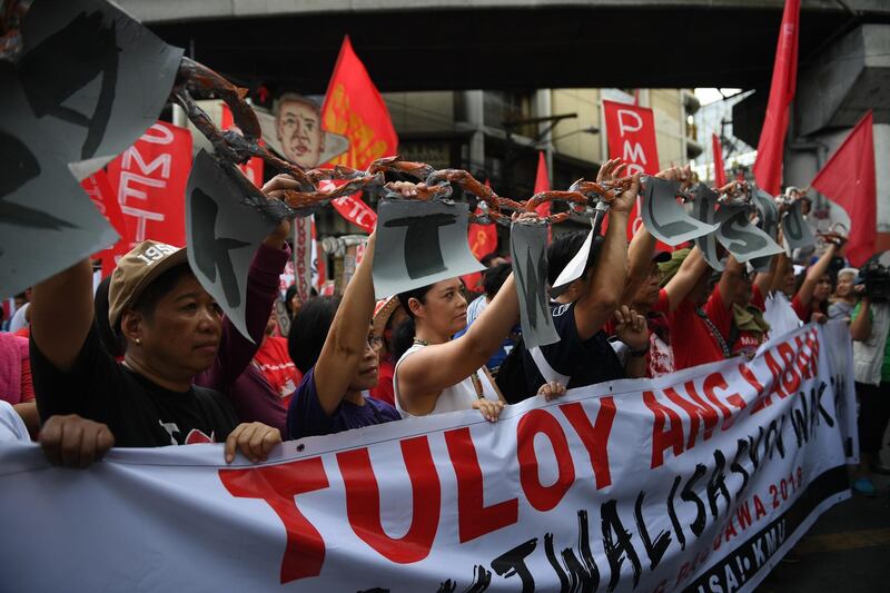Activists along with workers hold a mock chain as they march towards Malacanang Palace during the May Day rally in Manila. Ted Aljibe / AFP