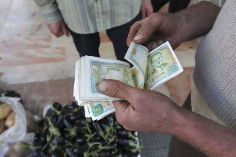 A vendor counts Syrian currency notes in Damascus. Muzaffar Salman / Reuters
