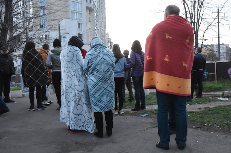 Residents wrapped in blankets stand near their houses damaged by Russian shelling in Odesa. AP