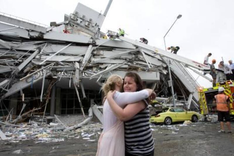 Two women hug each other in front of a collapsed building in central Christchurch February 22, 2011. A strong quake hit New Zealand's second-biggest city of Christchurch on Tuesday for the second time in five months, toppling buildings, causing "multiple fatalities," trapping people beneath rubble and sparking fires. REUTERS/Christchurch Press/John Kirk-Anderson (NEW ZEALAND - Tags: DISASTER ENVIRONMENT) NO SALES. NO ARCHIVES. FOR EDITORIAL USE ONLY. NOT FOR SALE FOR MARKETING OR ADVERTISING CAMPAIGNS. THIS IMAGE HAS BEEN SUPPLIED BY A THIRD PARTY. IT IS DISTRIBUTED, EXACTLY AS RECEIVED BY REUTERS, AS A SERVICE TO CLIENTS. AUSTRALIA OUT. NO COMMERCIAL OR EDITORIAL SALES IN AUSTRALIA. NEW ZEALAND OUT. NO COMMERCIAL OR EDITORIAL SALES IN NEW ZEALAND *** Local Caption ***  DGM15_NEWZEALAND-QU_0222_11.JPG