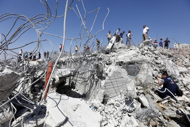 Palestinians inspect a house, which was demolished by the Israeli army in the West Bank city of Hebron. EPA
