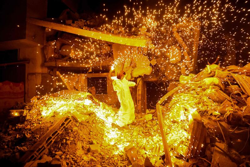 A Palestinian child plays with a sparkler in Rafah, in southern Gaza, on the eve of Ramadan. AFP