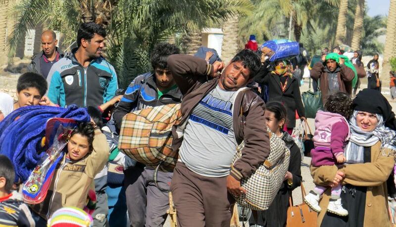 Displaced Iraqis, who fled regions controlled by ISIL near Fallujah, carry their belongings on February 9, 2016 as they arrive in the Jwaibah area, on the eastern outskirts of Ramadi, after pro-government troops retook it from the extremists. Moadh Al Dulaimi/AFP 