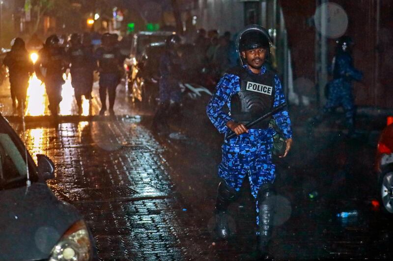 A Maldives policeman charges with baton towards protesters after the government declared a 15-day state of emergency in Male, Maldives, early Tuesday, Feb. 6, 2018. The Maldives government declared a 15-day state of emergency Monday as the political crisis deepened in the Indian Ocean nation amid an increasingly bitter standoff between the president and the Supreme Court. Hours after the emergency was declared, soldiers forced their way into the Supreme Court building, where the judges were believed to be taking shelter, said Ahmed Maloof, an opposition member of Parliament. (AP Photo/Mohamed Sharuhaan)