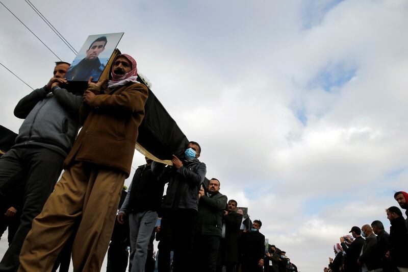 Mourners carry the remains of 104 Yazidis killed by ISIS for burial in the northern Iraqi village of Kocho on February 6, 2021. Reuters