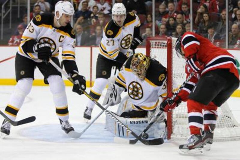 New Jersey Devils right wing Stephen Gionta (R) tries to get the puck between the goal post and the pad of Boston Bruins goalie Anton Khudobin (35) as Bruins defensemen Zdeno Chara (33) and Dougie Hamilton (27) defend in the first period of their NHL hockey game in Newark, New Jersey, April 10, 2013. REUTERS/Ray Stubblebine (UNITED STATES - Tags: SPORT ICE HOCKEY)