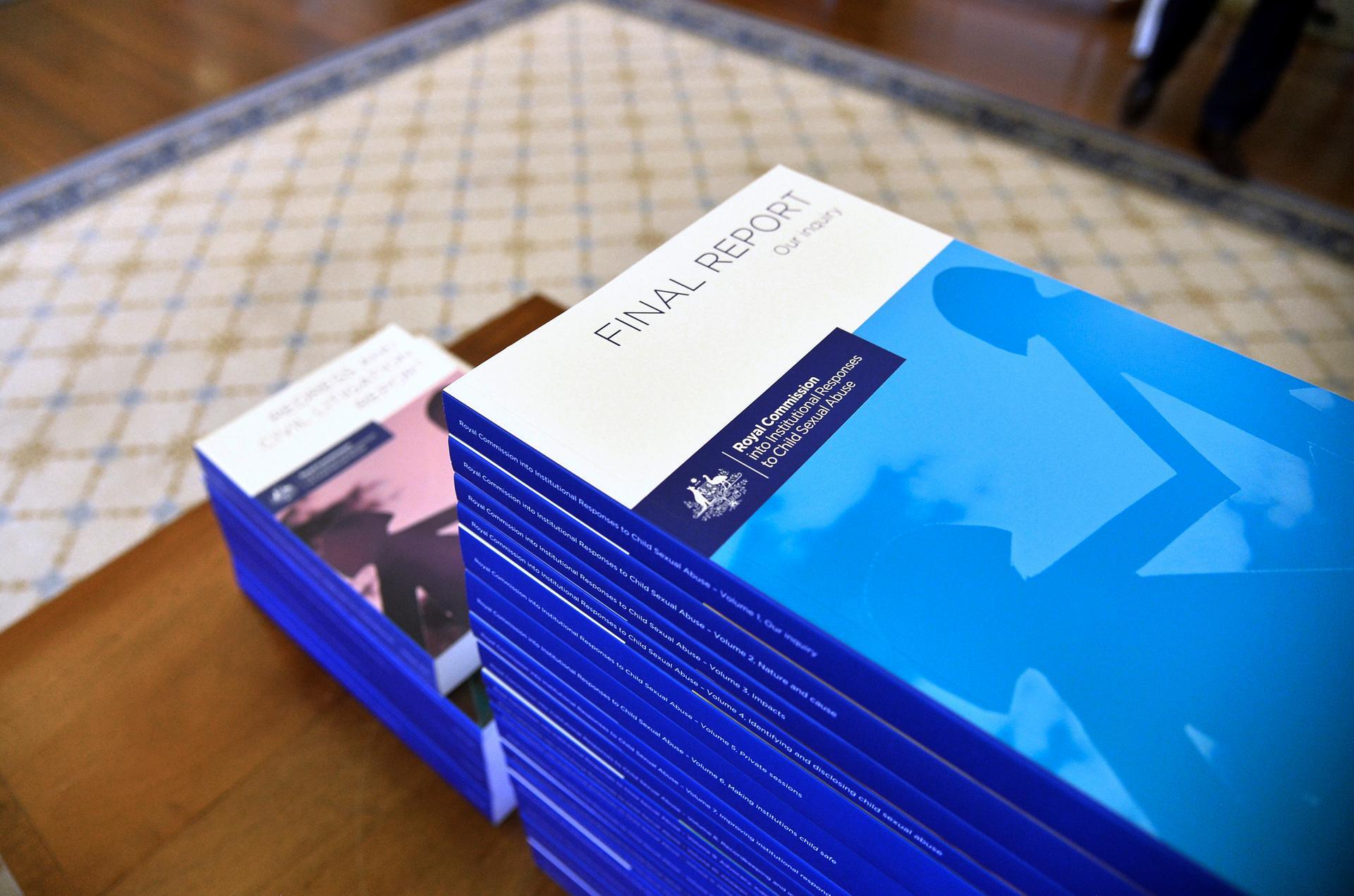 In this photo provided by the Australian Government Royal Commission, the volumes of the Final Report of the Royal Commission into Institutional Responses to Child Sexual Abuse sit on a table at Government House, in Canberra, Dec. 15, 2017. The commission delivered its final 17-volume report and 189 recommendations following a wide-ranging investigation. (Jeremy Piper/Australian Government Royal Commission via AP)