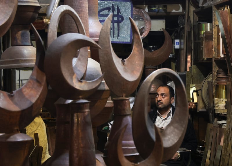 A vendor of copper Islamic figures at his shop at El Moez Street in Cairo, Egypt. Reuters