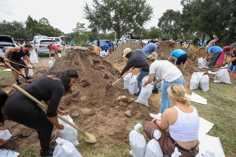 Residents and city workers fill sandbags at West Park in downtown Clermont, Florida, in preparation for Hurricane Ian. AP