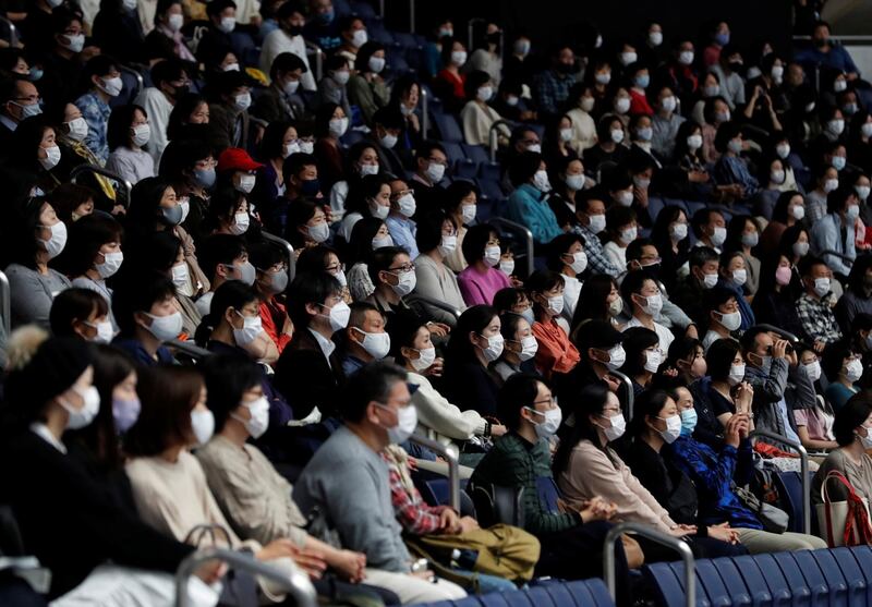 Spectators wearing protective masks watch the action in Tokyo. Reuters