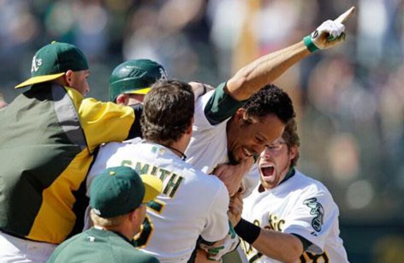 Coco Crisp is mobbed by his Oakland Athletics teammates after hitting the winning run agains the New York Yankees