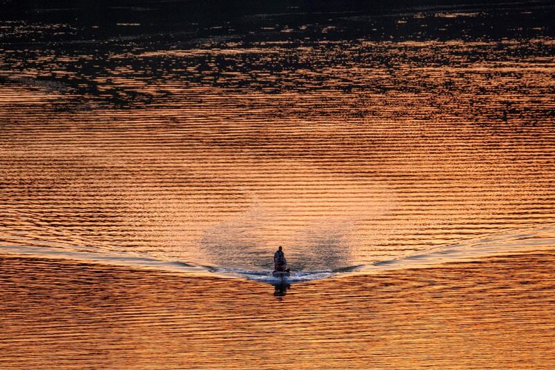 A fishing boat cruises along the Potomac River at sunset in Washington state, US.  AP Photo