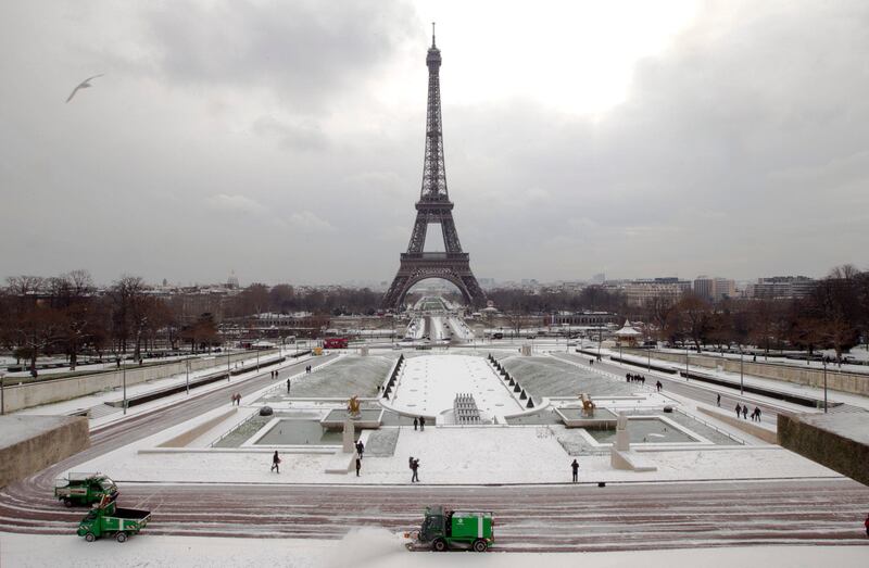 Vehicles clear snow from the ground near the Effeil Tower seen in background, in Paris, Sunday  Feb. 5, 2012. Freezing weather is affecting huge areas of Europe disrupting traffic. (AP Photo/Jacques brinon) *** Local Caption ***  France Europe Weather.JPEG-00514.jpg