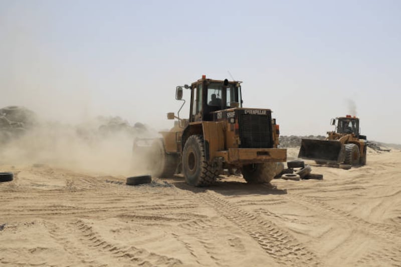 Earth-moving equipment is used to manage the huge volume of old tyres at the site.