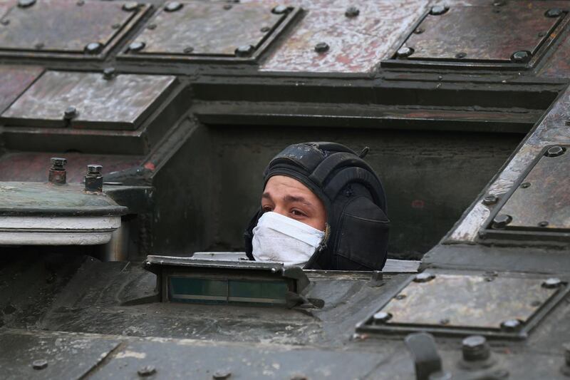 A Russian serviceman wearing a protective mask looks out of a military vehicle during a rehearsal for the Victory Day parade in Yekaterinburg, Russia. Reuters