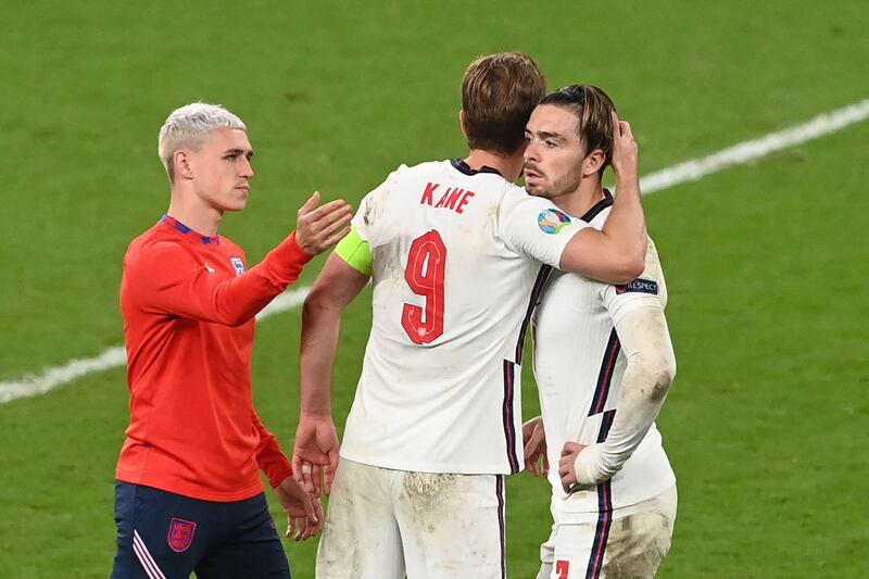 England's Manchester City midfielder Phil Foden, left, consoles Harry Kane and Jack Grealish following a shoot-out defeat to Italy in the Euro 2020 final at Wembley. AFP