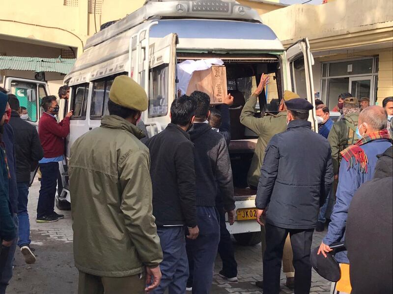 Policemen help to load coffin of a victim of a stampede from community health centre in Katra, near Jammu, India, Jan. 1, 2022.  A stampede at a popular religious Hindu shrine has killed at least 12 people and injured 12 others on New Year's Day in Indian-controlled Kashmir early Saturday, officials said.  Authorities were investigating what caused the stampede at Mata Vaishnav Devi shrine where tens of thousands of Hindu devotees assemble daily to pay their obeisance in hilly Katra town near southern Jammu city.  (AP Photograph / Channi Anand)