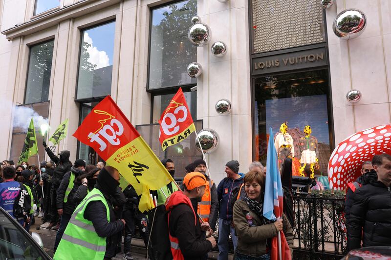 Demonstrators, including French General Confederation of Labour (CGT) trade unionists, gather in front of the store. AFP