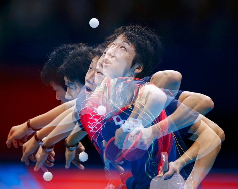 Japan's Jun Mizutani serves to Hong Kong's Leung Chu Yan in their men's team quarterfinals table tennis match at the ExCel venue during the London 2012 Olympic Games August 5, 2012.  Picture taken on multiple exposures. REUTERS/Darren Staples (BRITAIN  - Tags: OLYMPICS SPORT TABLE TENNIS TPX IMAGES OF THE DAY)  