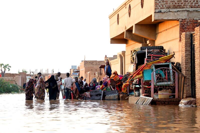 Residents carry their belongings after severe flooding in the Umm Dum area, east of Khartoum, Sudan. EPA