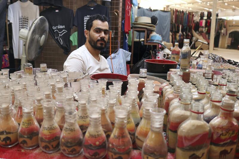 Artisan Nadim Tantawi crafts a decorative sand bottle at his stand in the empty visitors center at Jerash, Jordan on October 21, 2020  