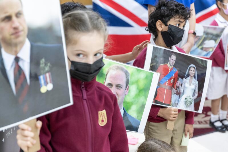 Pupils hold placards of Prince William. 