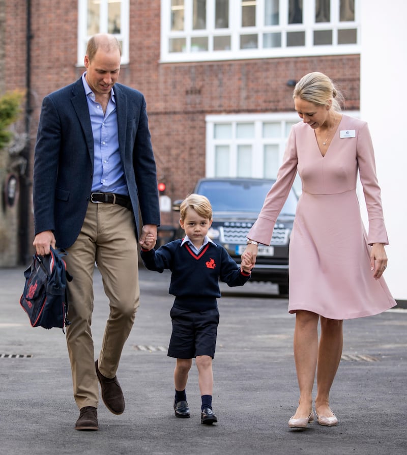 Britain's Prince William, left, accompanies Prince George and Helen Haslem - the head of the lower school on arrival for his first day of school at Thomas's school in Battersea, London, Thursday, Sept. 7, 2017.  Prince William's pregnant wife Kate was too ill with morning sickness Thursday to take young Prince George to his first day of school.  (Richard Pohle/Pool Photo via AP)