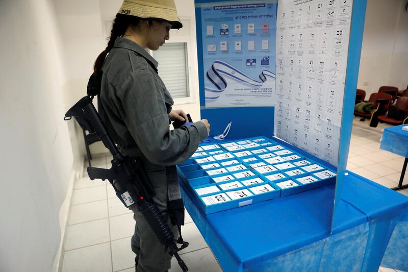 An Israeli border policewoman stands behind a mobile voting booth at a base in Beit Horon settlement. Reuters