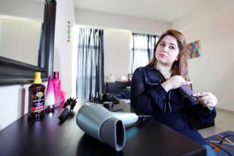 Ajman, August 2, 2012 -- University graduate Nabaa Al Dabbagh, 21, claims she lost a third of her hair volume since she moved to Ajman from Iraq in 2005. Dabbagh is photographed brushing her hair at her home in Ajman August 2, 2012. Photo by: Sarah Dea/The National)