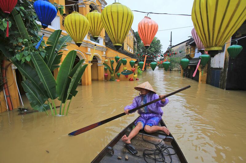 Nguyen Thi Vui paddles her boat in the flooded streets of Hoi An, Vietnam. Hau Dinh / AP Photo