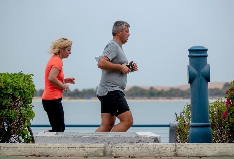 Runners take advantage of the cool weather on the Corniche in Abu Dhabi. Victor Besa / The National