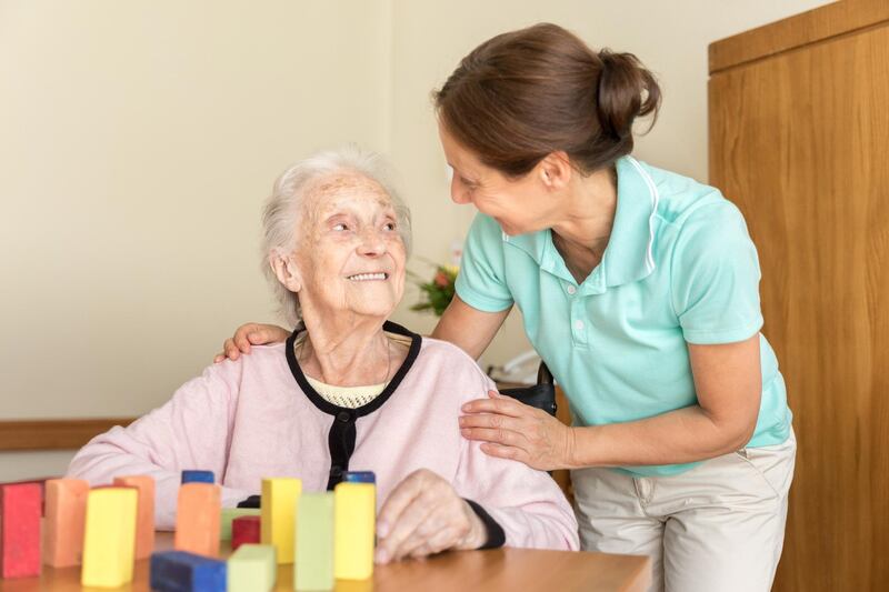 Dementia – Home Caregiver and Senior Adult Woman. Getty Images