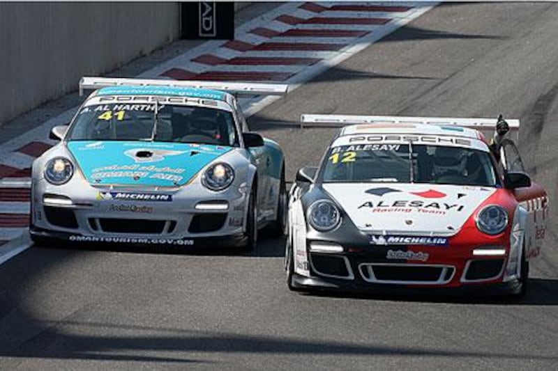 Bandar Alesayi, right, gives Ahmad Al HArthy the thumbs up after the Omani driver won the Porsche GT3 Cup Middle East race.