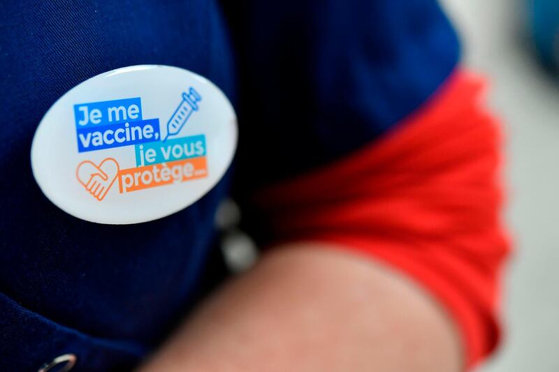 A nurse wears a badge reading "I get vaccinated, I protect you" at the Cavale Blanche hospital in Brest, western France during a vaccination operation of the medical staff against the Covid-19 disease. AFP