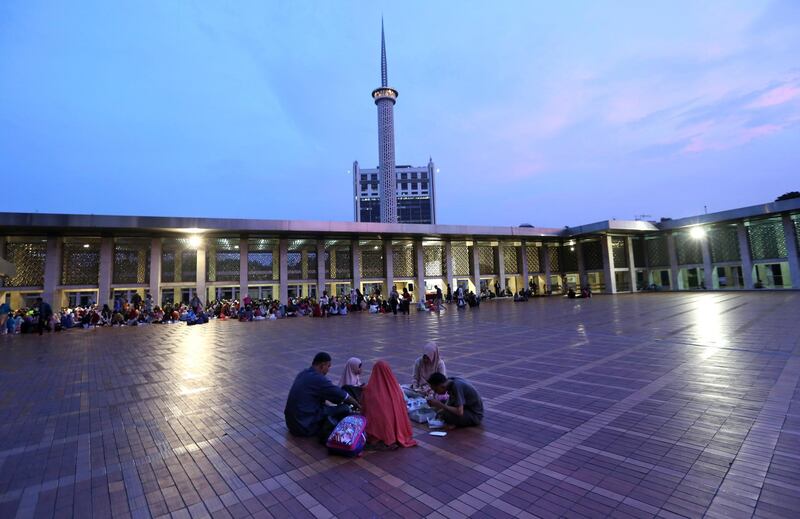 A family break their fast at the end of the first day of the holy fasting month of Ramadan at Istiqlal Mosque in Jakarta, Indonesia, on May 17, 2018. Tatan Syuflana / AP Photo