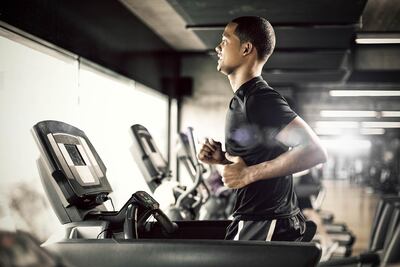 Healthy young man in GYM running on treadmill