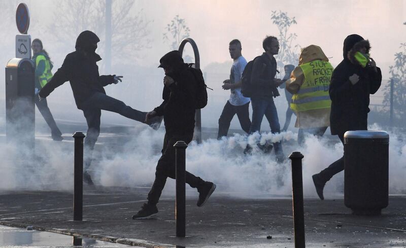 People run through tear gas on November 17, 2018 in Quimper, western France, during a nationwide popular initiated day of protest called "yellow vest" (Gilets Jaunes in French) movement to protest against high fuel prices. Two policemen were wounded on November 17, 2018 in Quimper after being deliberately struck by a vehicle that took part in the demonstration of "yellow vests", announced the prefecture of Finistere in a statement.
More than 120 000 people were taking part in more than 2000 protests at roundabouts and motorway exits, Interior Minister said. Most protests were relatively calm despite the anger expressed by many in interviews and on social media in recent days over the surge in fuel prices this year, in particular for diesel. / AFP / Fred TANNEAU
